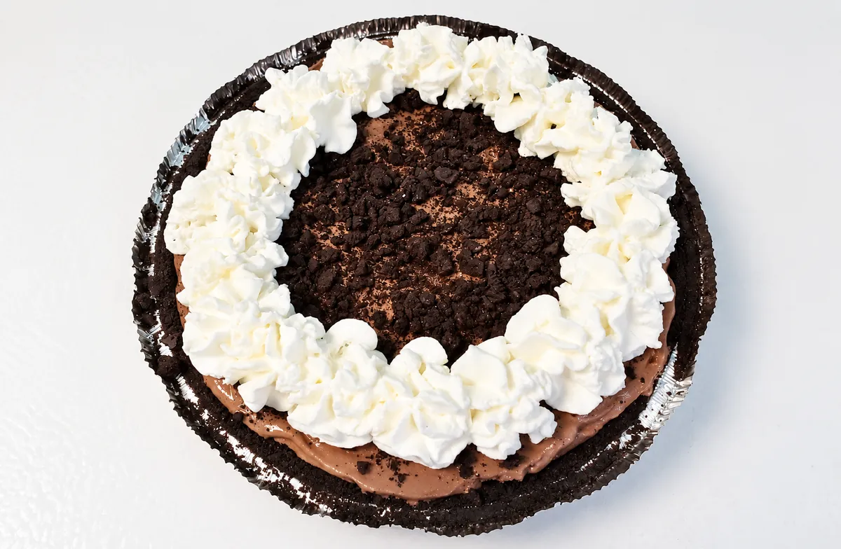 A chocolate ice cream pie with whipped cream and cookie crumbs